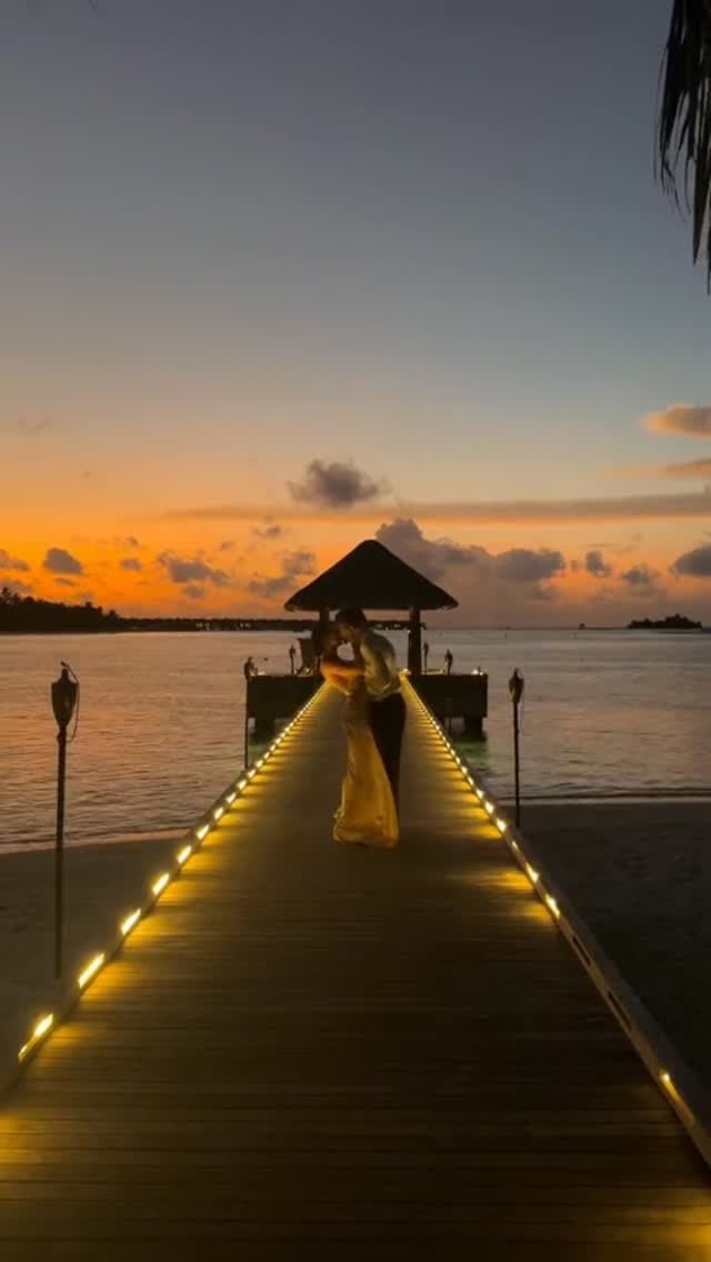 Pareja disfrutando el atardecer sobre un muelle